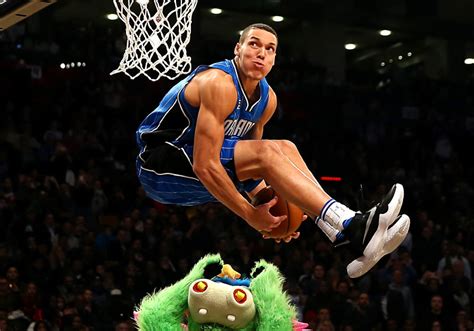 Aaron gordon soaring over a mascot for a dunk